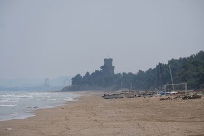 Boats on shore against clear sky