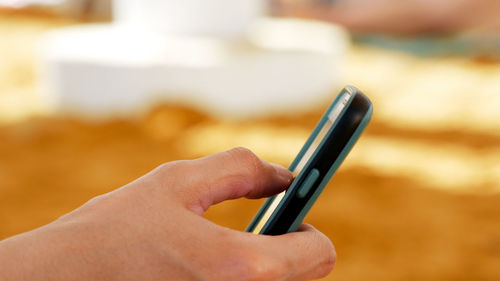 Close-up of hand holding mobile phone