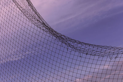 Low angle view of barbed wire fence against sky