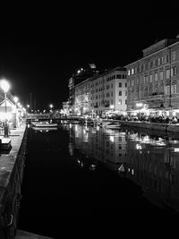 Illuminated buildings by street in city at night