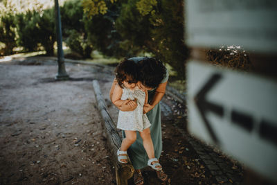 Woman having fun with daughter on sidewalk