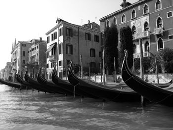 Boats moored in city against clear sky