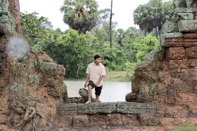 Man amidst old ruins against trees