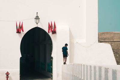 Rear view of man walking by building