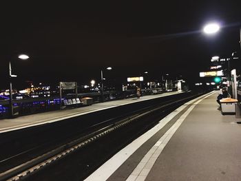 Illuminated railroad station platform at night
