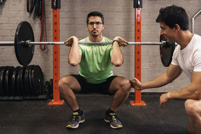 Personal trainer correcting habits in the exercise room. personalized individual training