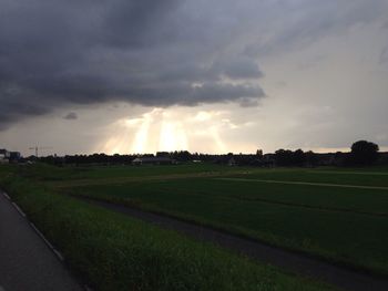 Scenic view of grassy field against cloudy sky