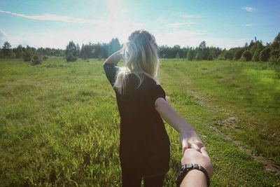 Cropped image of man holding girlfriend hand at park