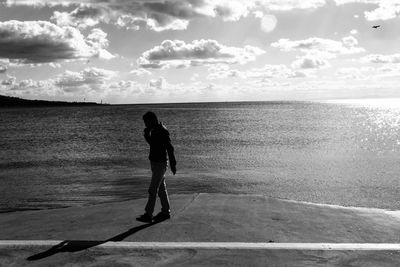 Full length of man walking at beach against sky