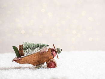 Christmas  wooden  plane carrying christmas tree for holiday and blurred background glowing garland. 