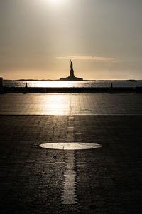 Scenic view of statue of liberty silhouette against the sky during sunset  from battery park