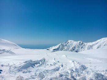 Scenic view of snowcapped mountains against clear blue sky