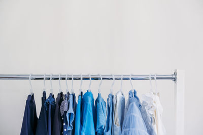 Fast fashion, sustainable fashion, minimalist wardrobe. variety of female blue clothing on hanging 