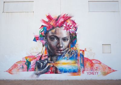 Portrait of young woman against multi colored wall