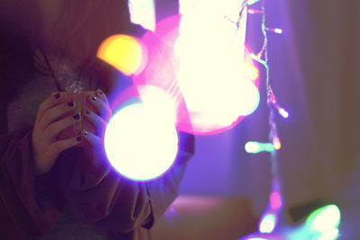 Close-up of hand holding illuminated lighting equipment