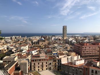 High angle view of townscape by sea against sky