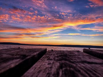 Surface level of wood against sea and sky during sunset