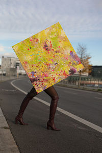 Low section of woman holding umbrella