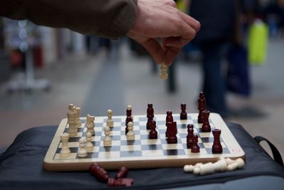 Close-up of man playing on chess board