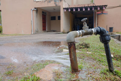 Water flowing from pipe by building