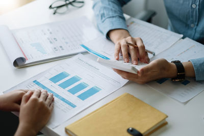 Midsection of business colleagues working on table