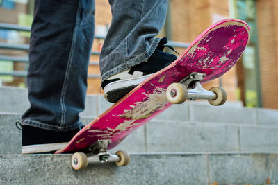 Low section of man holding skateboard