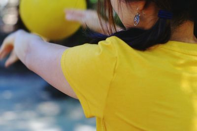 Rear view of woman against yellow sky