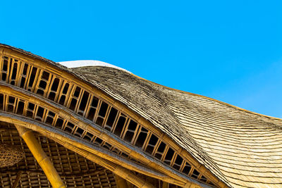 Low angle view of hut against clear blue sky