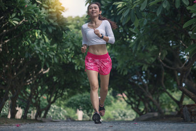 Full length portrait of a smiling young woman outdoors