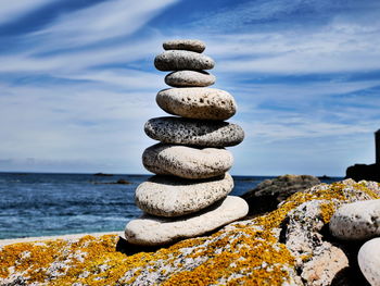 Stack of pebbles on beach against sky