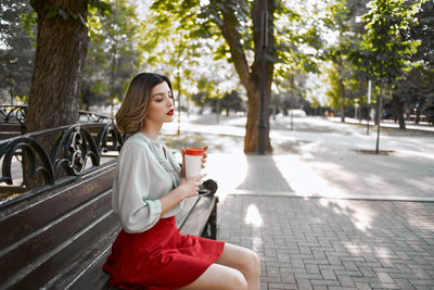 Side view of a young woman sitting outdoors