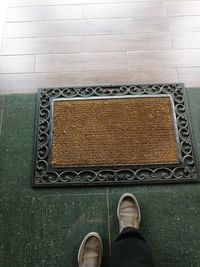 Low section of man standing on tiled floor