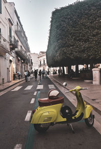 Vehicles on road against sky in city