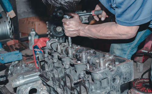 Midsection of man repairing machinery