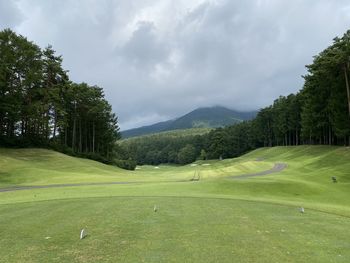 Scenic view of golf course against sky