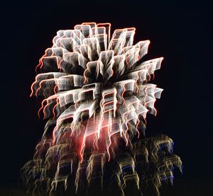 Low angle view of illuminated lighting equipment against black background