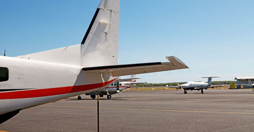 Airplane on airport runway against clear blue sky