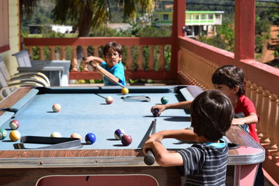 Cute children playing pool at porch