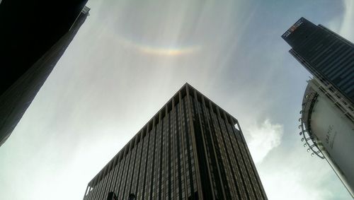 Low angle view of modern building against cloudy sky