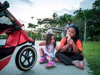 Shot of a two young girls eating ice cream outdoors in the park.