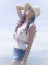 Woman wearing hat standing against sky