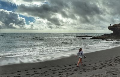 Woman on beach against sky at night