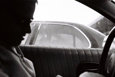 Portrait of man seen through car windshield