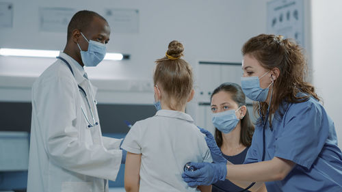 Female doctor examining patient in clinic