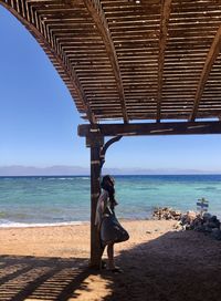 Rear view of man looking at sea against sky