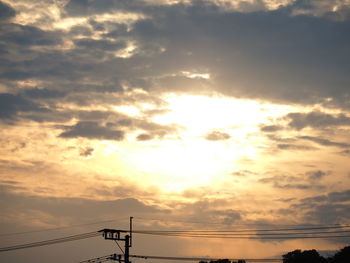 Low angle view of silhouette electricity pylon against sky during sunset