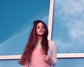 Portrait of woman standing against wall