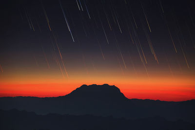 Scenic view of silhouette mountains against sky at night