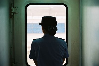 Rear view of man standing in bus