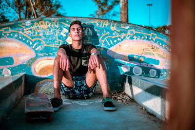 Teenager sitting at a skate park